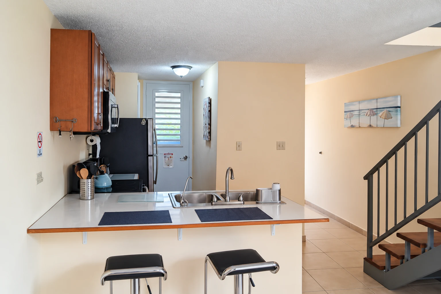 Cocina con barra de desayuno y escaleras
